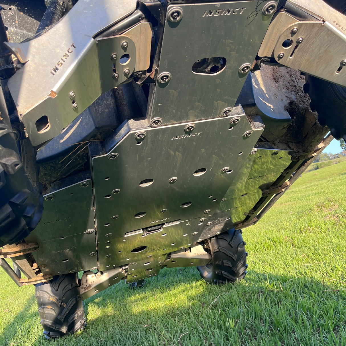 Side view of a CFMoto UForce 600 equipped with the installed InSinct 5mm underbody skid plate, ready for off-road use.