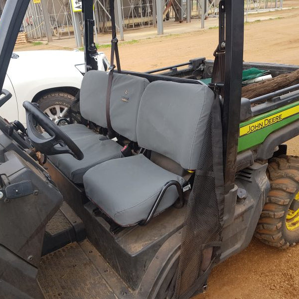 Close-up of rugged canvas seat cover on John Deere Gator, showing reinforced stitching and premium material