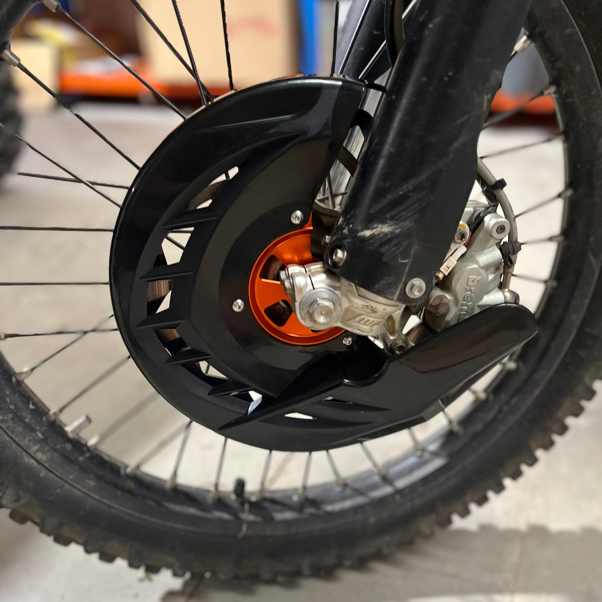 Underside perspective of the brake disc guard highlighting the internal structure and mounting design of the polypropylene shield and aluminium hub.