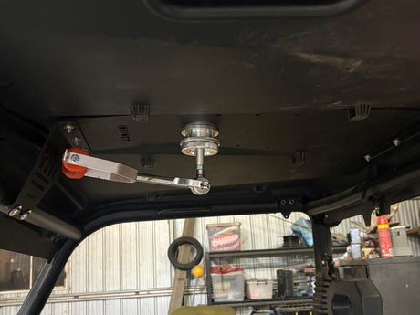 Close-up of the InSinct spotlight roof mounting plate on a CFMoto UForce 600 with spotlight attached.